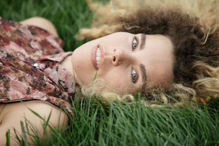 Woman lay and rest on a grass, closeup portrait