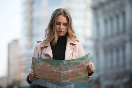 Tourist woman traveller looking to map standing in european city streetの写真素材