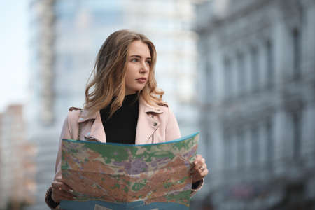 Tourist woman traveller looking to map standing in european city streetの写真素材
