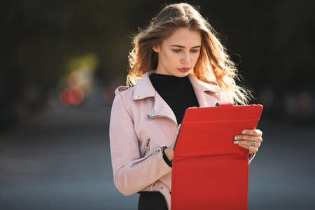 Young woman using tablet PC in city. Dark background.の写真素材