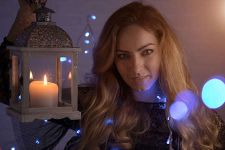 Woman in garland holding christmas lampの写真素材