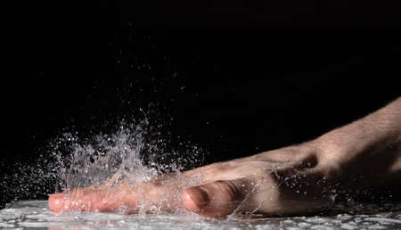 Splash of water drops after clap hand on the table