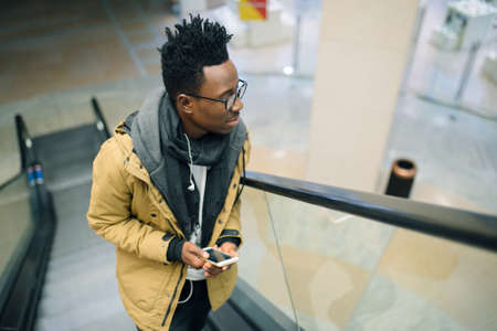Portrait of the young african man go up on the escalatorの写真素材
