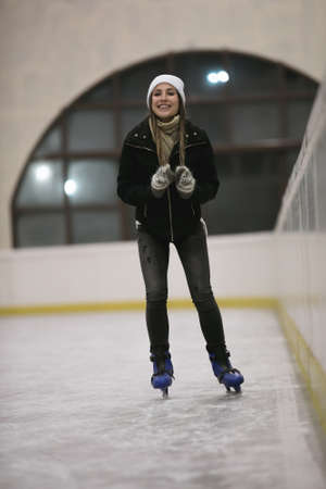 Happy woman skating on an ice rink