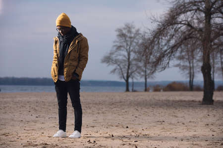 Depressed man standing alone on winter beachの写真素材