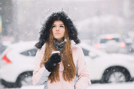 Young woman enjoy drink hot beverage from coffee cup at winterの写真素材