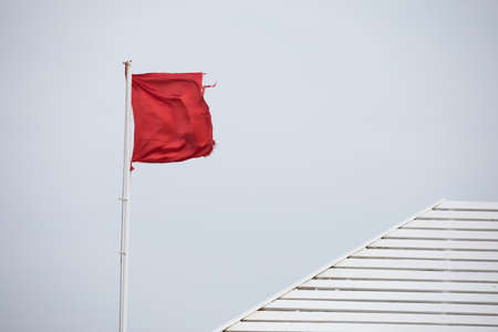 Empty red flag on a windの写真素材