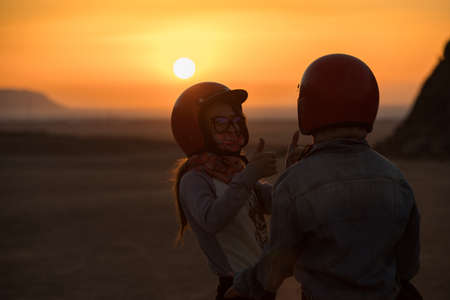 Women tourists with helmet, morning sunrise in desert, happy thumbs upの写真素材