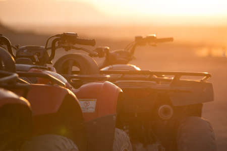 A lot of ATV in sunrise beam in Egypt desertの写真素材