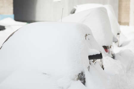 Snowdrifts on a winter day. Cars in the yard after heavy snow storm.の写真素材