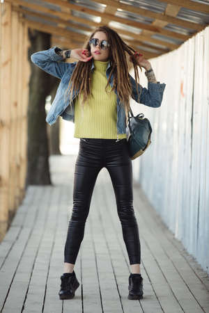 Stylish woman with dreadlocks, fashion portrait in city