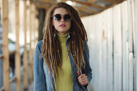 Stylish woman with dreadlocks, fashion portrait in cityの写真素材