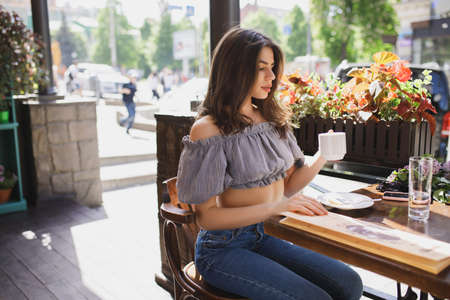 Pretty young woman drinking tea in restaurantの写真素材