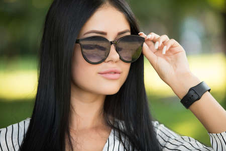 Beautiful young woman in sunglasses closeup portrait, hair after keratin treatmentの写真素材