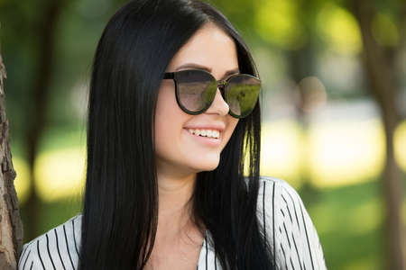 Beautiful young woman in sunglasses closeup smiling portraitの写真素材