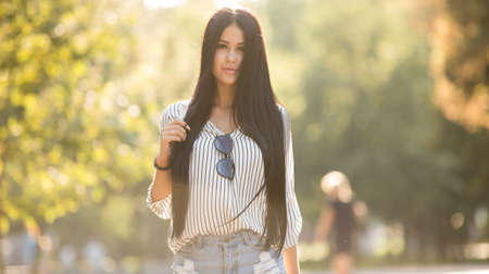 Pretty woman walking in summer park, her hair is so beautifulの写真素材