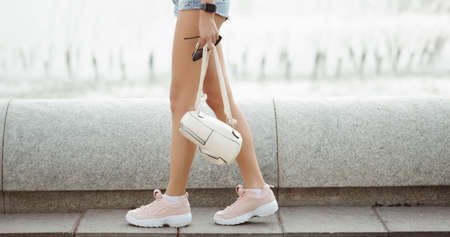 Cropped shot of woman holding backpack in hand