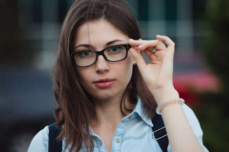 Student girl portrait outdoors closeup in eye glasses for good visionの写真素材