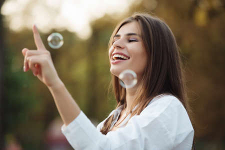 Happy girl catches soap bubblesの写真素材