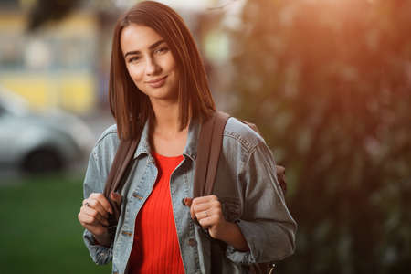 Woman in autumn season clothes with backpack at the park
