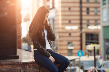 Woman sitting in urban city streetの写真素材