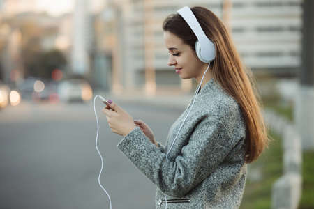 Woman listening to music with headphones in cityの写真素材