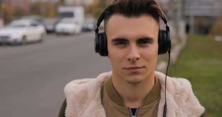 Young man listening to music in headphones at cityの写真素材
