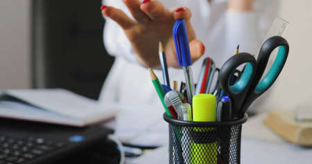 Businesswoman working on background, she take a pen and writing documentの写真素材