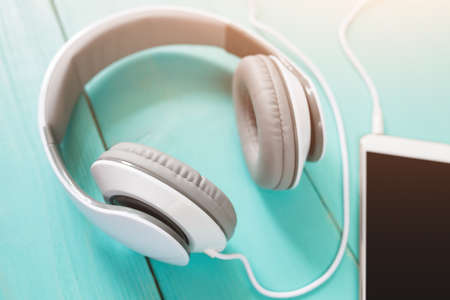 Headphones and smartphone on the wooden desk, tonedの写真素材