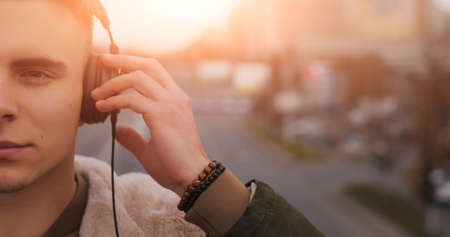 Half face of young man listening a music with headphones in cityの写真素材