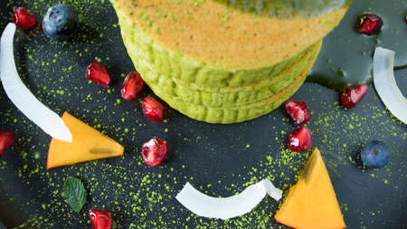 Delicious cake with matcha tea powder in plate, top viewの写真素材