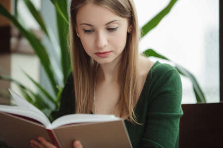 Woman reading book in the cafe