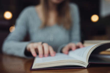 Woman reading book in cafe close up
