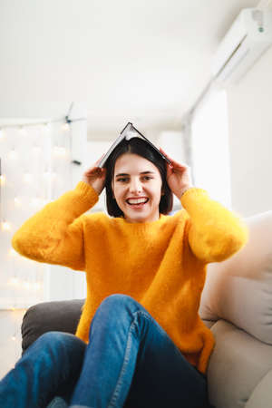Funny woman portrait of woman with book on a head