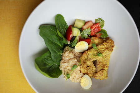 Plate with chicken curry and salad, top view, yellow and black backgroundの写真素材