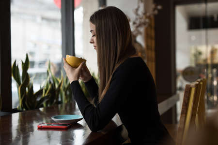 Woman having coffee break sitting in a cafeの写真素材