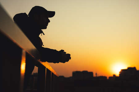 Silhouette of the dreaming man in city sunset looks forward at cityscapeの写真素材