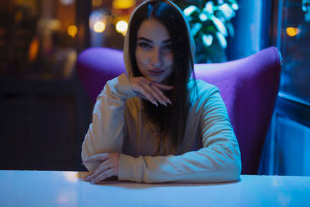 Attractive woman portrait sitting in a night clubの写真素材
