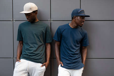 African men models posing in t-shirts leaning on building wallの写真素材