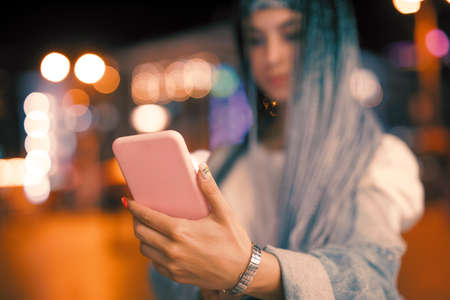 Woman holding smart phone and give your number at night cityの写真素材