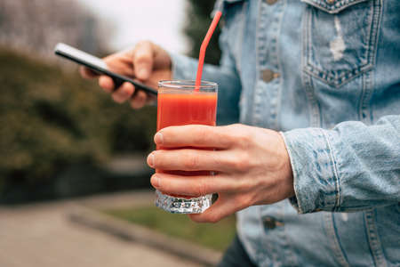 Person holding tomato juice in a glass at summerの写真素材