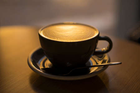 Classical latte in a cup on the wooden tableの写真素材