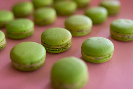 Green sweet macaroons on the pink background