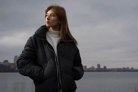 Portrait of woman in winter wear against city backgroundの写真素材