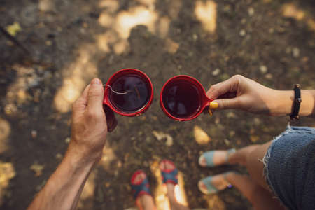 Couple holding cups with tea on their hiking wayの写真素材