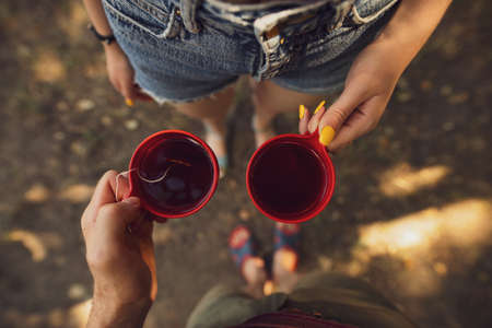 Couple holding cups with tea on their hiking wayの写真素材
