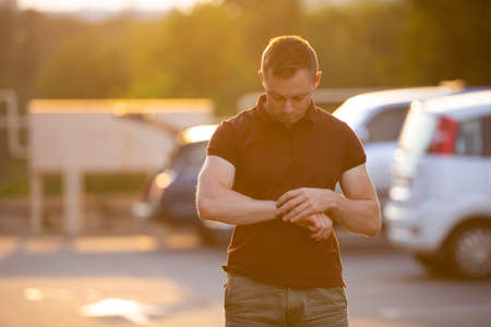 Fashion man in brown polo at the summer city parkingの写真素材