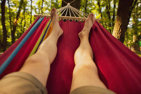 Male legs chill out lying on hammockの写真素材