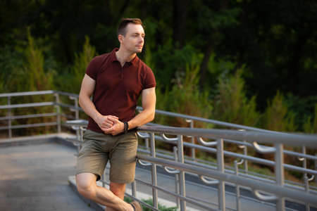 Fashion man in a brown polo posing outdoorの写真素材