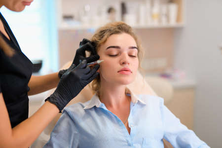 Biorevitalization, beautician make face injections procedure in a beauty salon